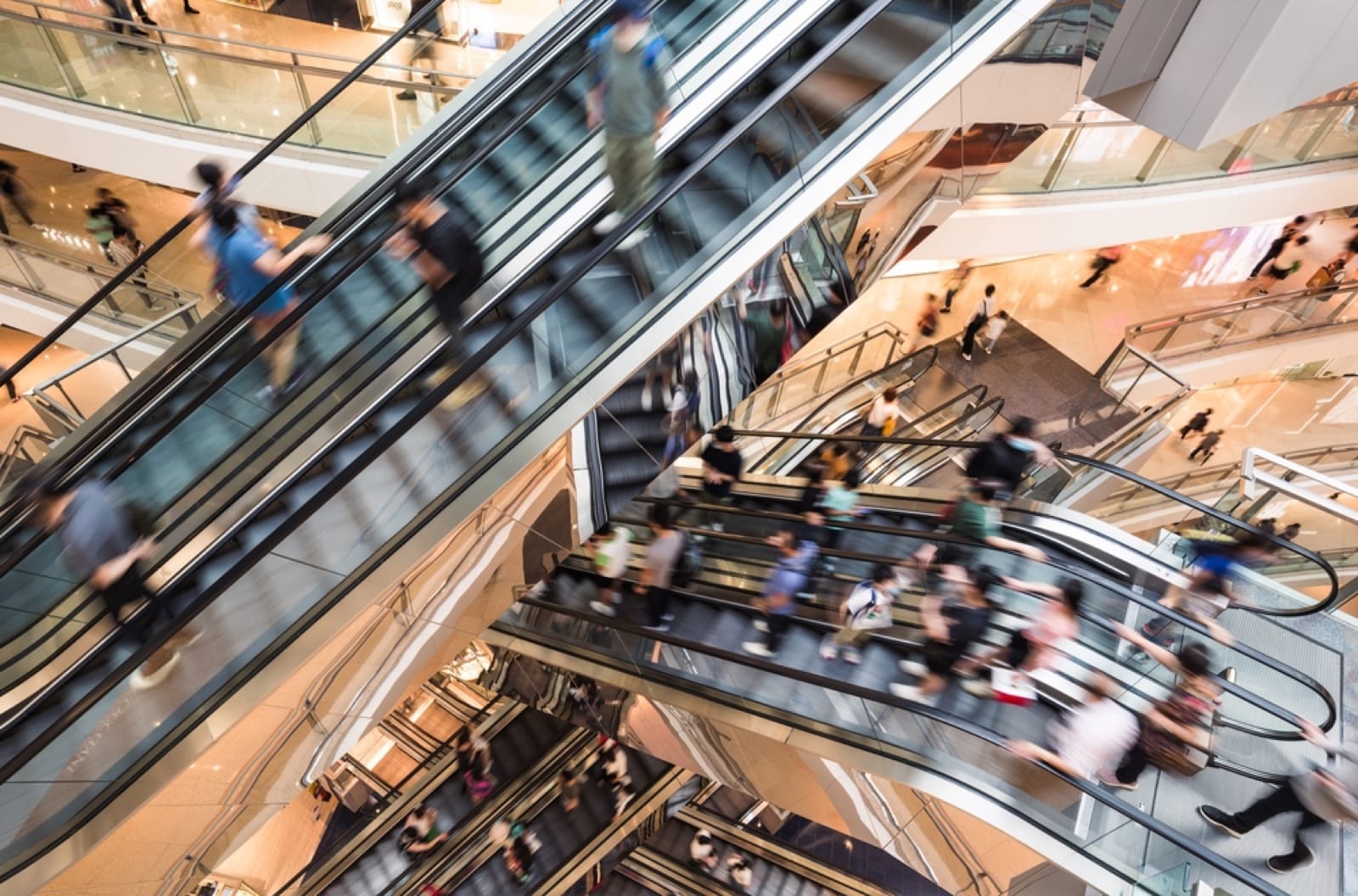 Shoppers on escalators in a busy shopping centre